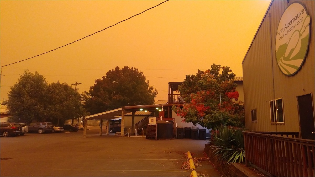 The South parking lot at the First Alternative Natural Foods Co-op under a thick orange haze of wildfire smoke.