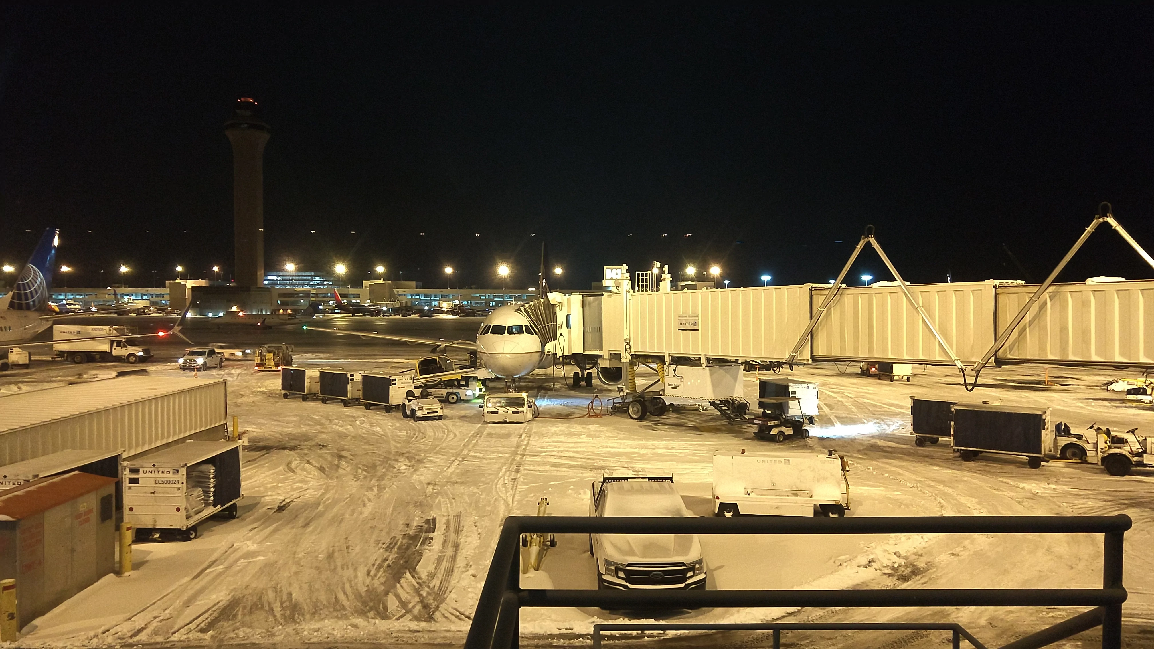 Airliner at the jetway on a snowy night at Denver International Airport